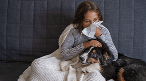 A poorly child is comforted by her dog