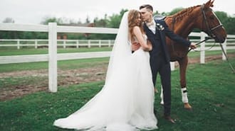 a bride and groom posing for a photo in front of their horse