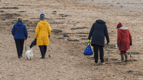 4 people participating in a beach clean