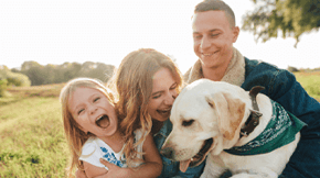 A family of 4, mum, dad, daughter and their labrador